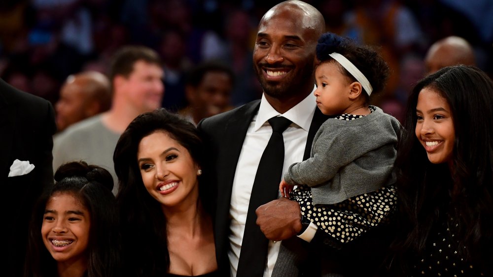 Kobe Bryant pose avec sa famille à la mi-temps après le retrait de ses maillots # 8 et # 24 des Los Angeles Lakers