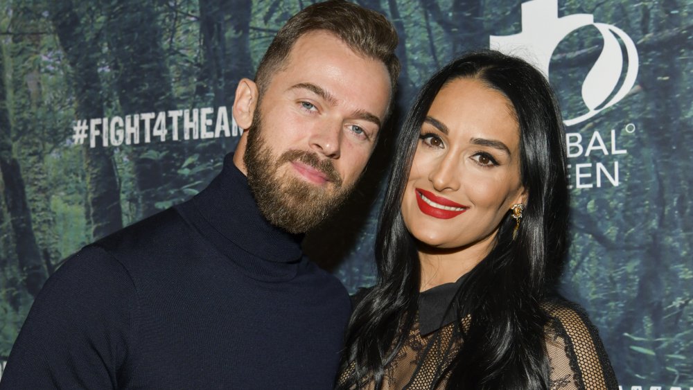 Artem Chigvintsev et Nikki Bella posant à l'événement FIGHT4THEAMAZON