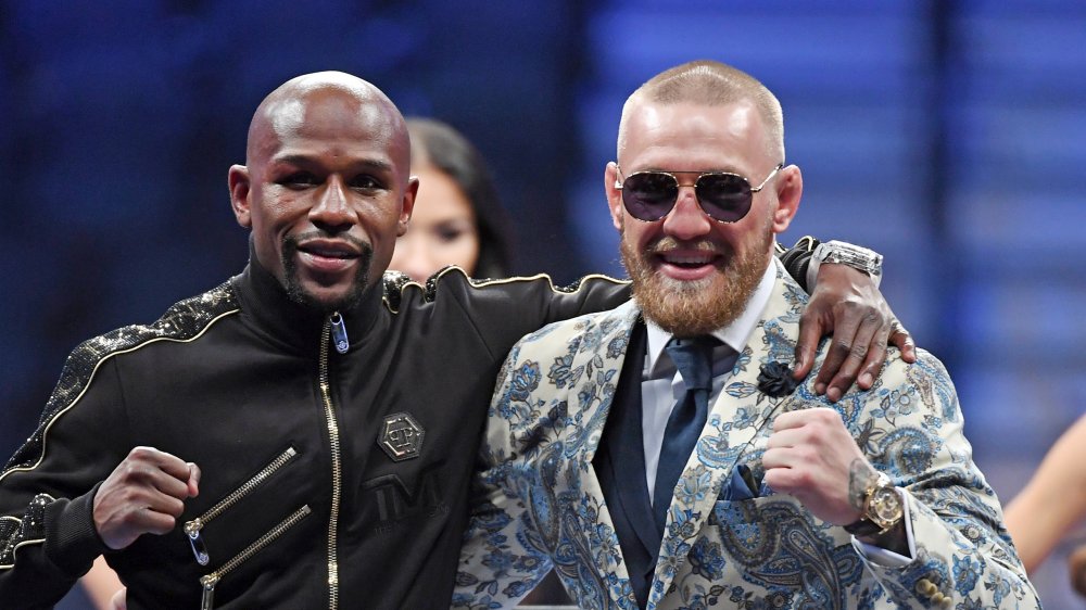 Floyd Mayweather et Conor McGregor avec les bras l'un autour de l'autre