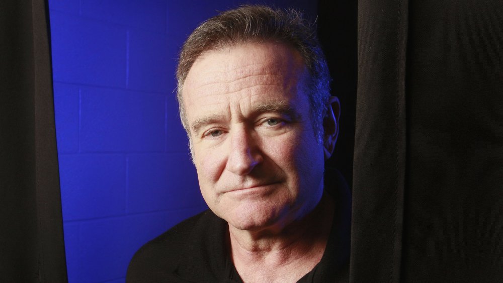 Robin Williams a l'air triste à côté d'un rideau