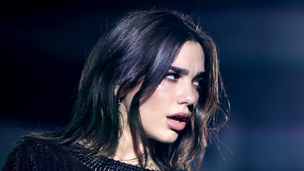 Dua Lipa making an unhappy face, looking off to the side