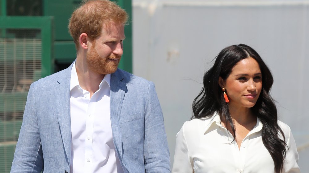 Prince Harry et Meghan Markle marchant à l'extérieur