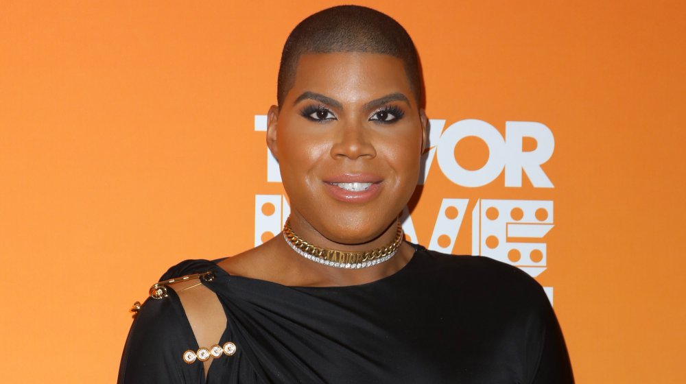 EJ Johnson en tenue noire et colliers dorés et argentés