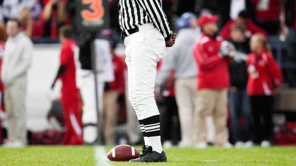 Arbitre de la NFL avec ballon sur la ligne de touche 