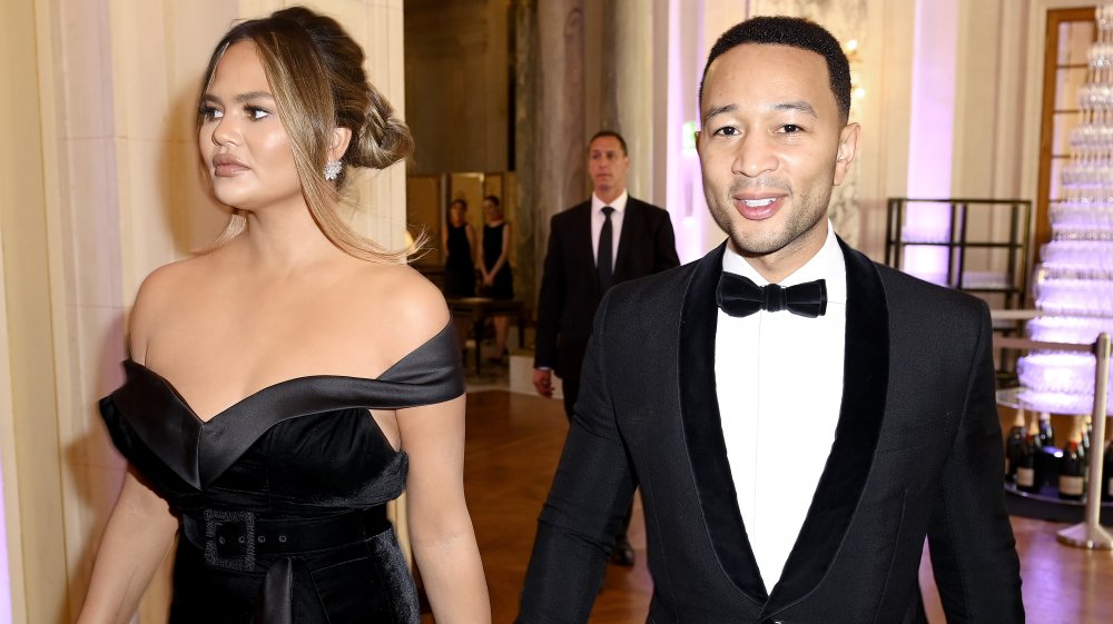 Chrissy Teigen et John Legend marchant ensemble à l’événement formel