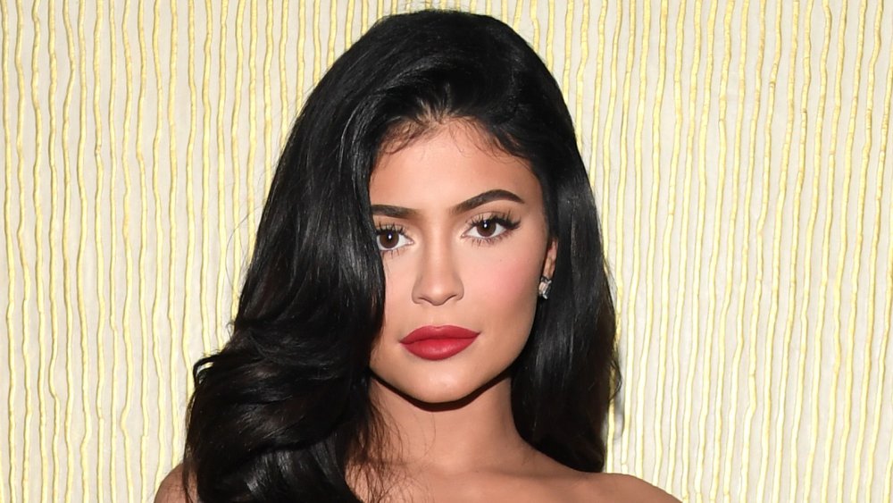 Kylie Jenner dans une robe rouge, posant avec une expression neutre