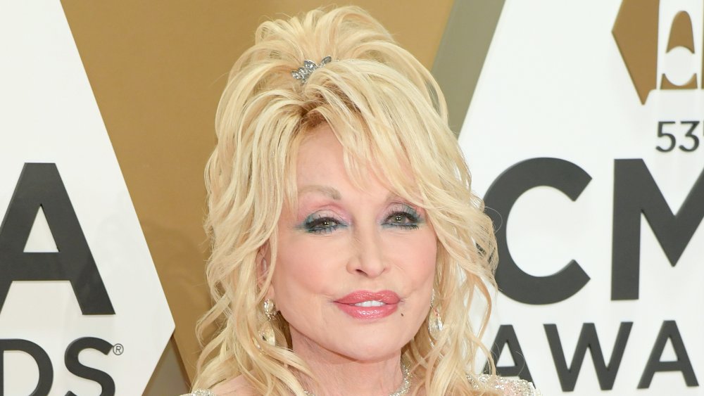 Dolly Parton dans une robe blanche scintillante, posant aux CMA Awards