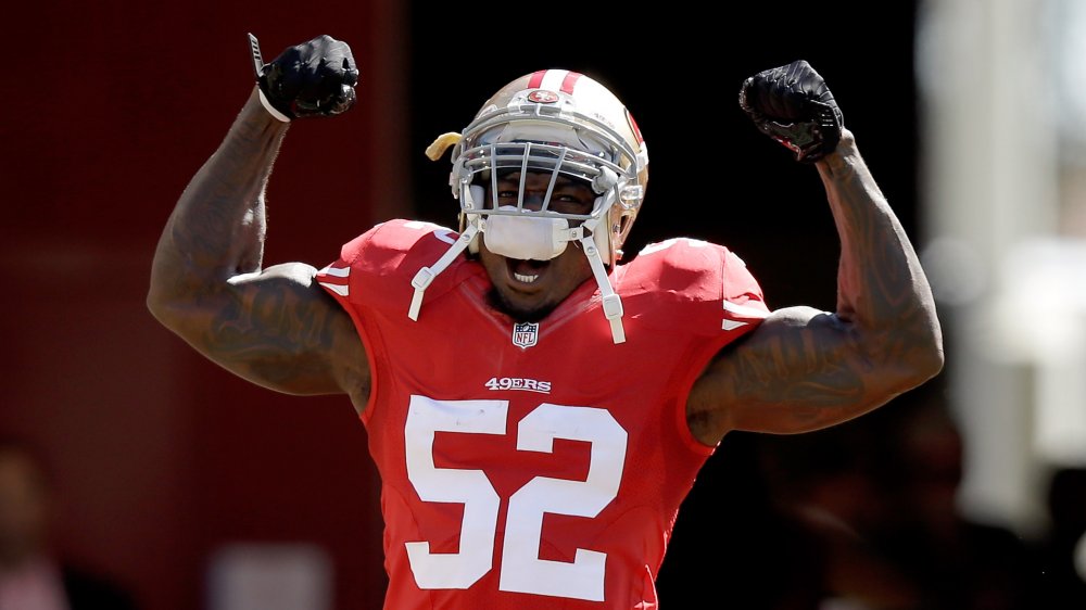 Patrick Willis criant avec ses bras vers le haut tout en célébrant sur le terrain