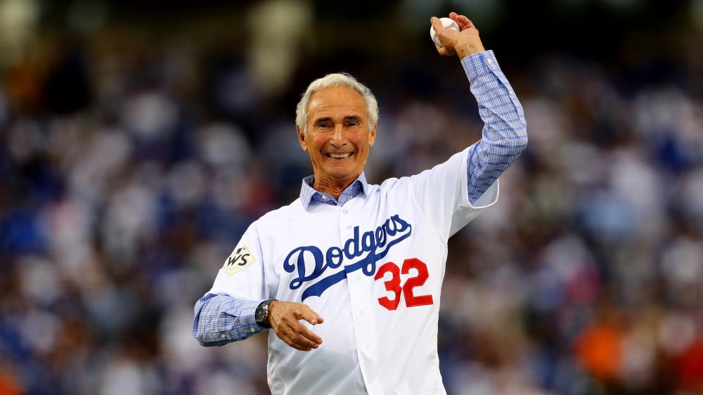 Un vieux Sandy Koufax souriant tout en jetant un pas