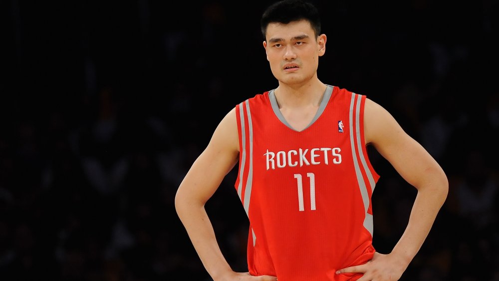 Yao Ming debout avec ses mains sur ses hanches sur le court