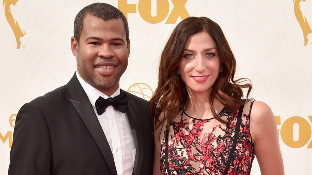 Jordan Peele en costume noir, Chelsea Peretti dans une robe noire et rouge