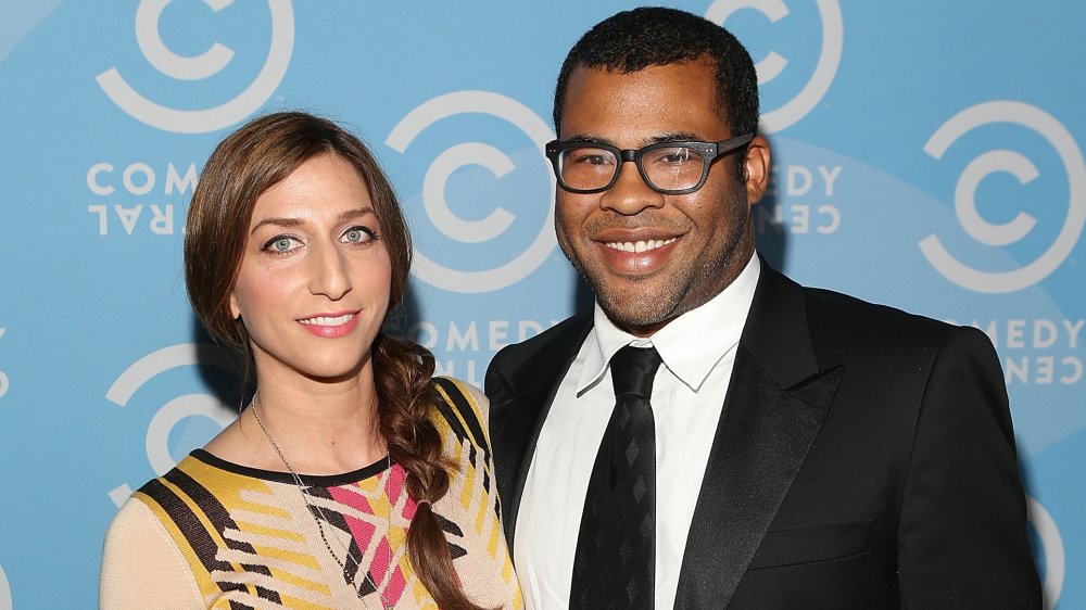 Chelsea Peretti dans une robe jaune et noire, Jordan Peele dans un costume noir et des lunettes