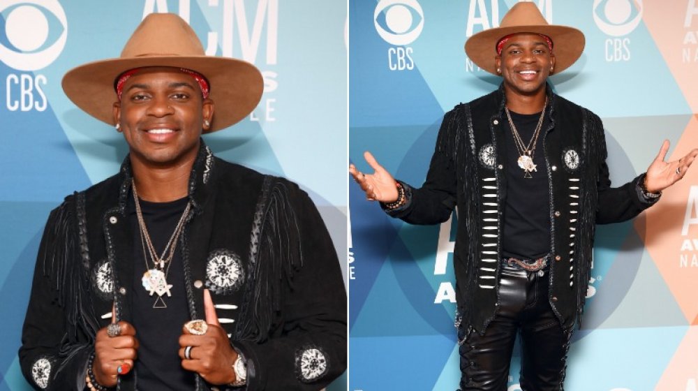 Jimmie Allen en chapeau brun à large bord et ensemble noir