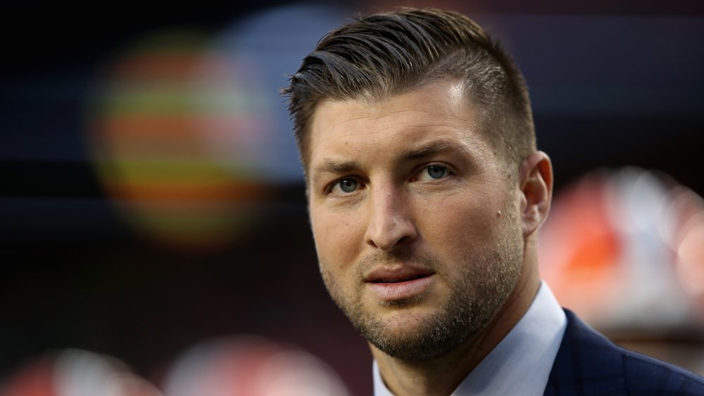 Tim Tebow en costume, avec une expression sérieuse