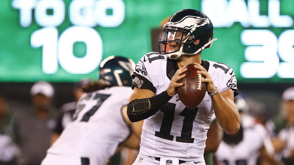 Tim Tebow sur le point de lancer un ballon de football dans un uniforme des Eagles de Philadelphie