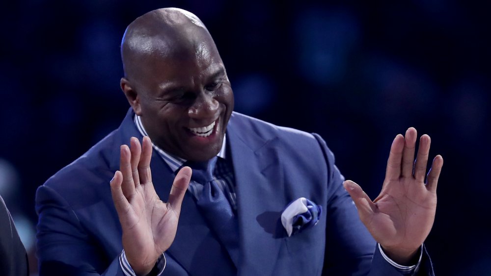 Magic Johnson avec les mains vers le haut, riant