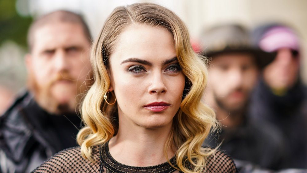 Cara Delevingne aux cheveux bouclés et haut en maille