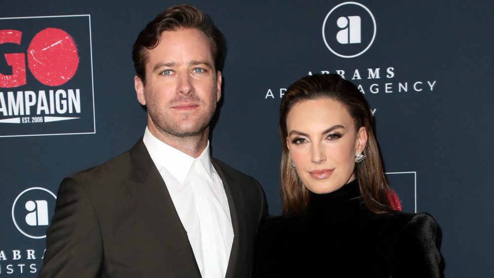 Armie Hammer et Elizabeth Chambers, posant avec des expressions sérieuses sur le tapis rouge