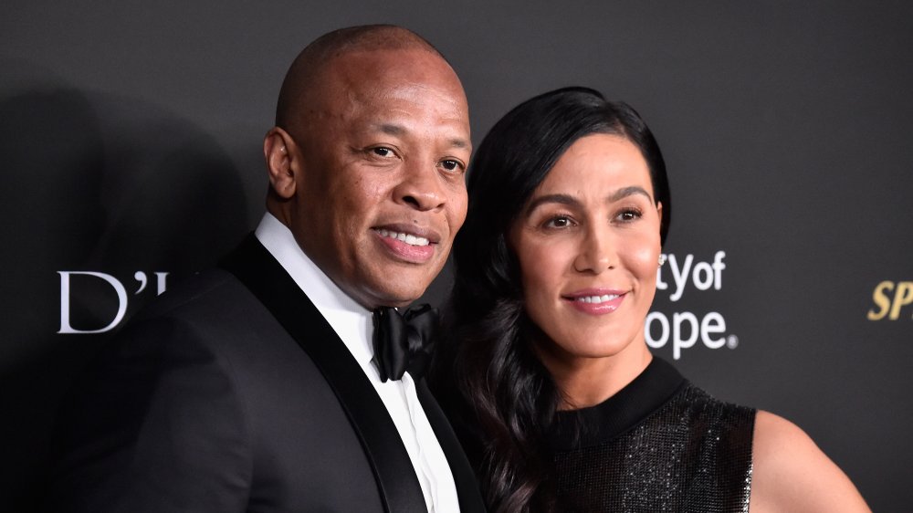 Dr Dre et Nicole Young, posant bras dessus bras dessous et souriant sur le tapis rouge