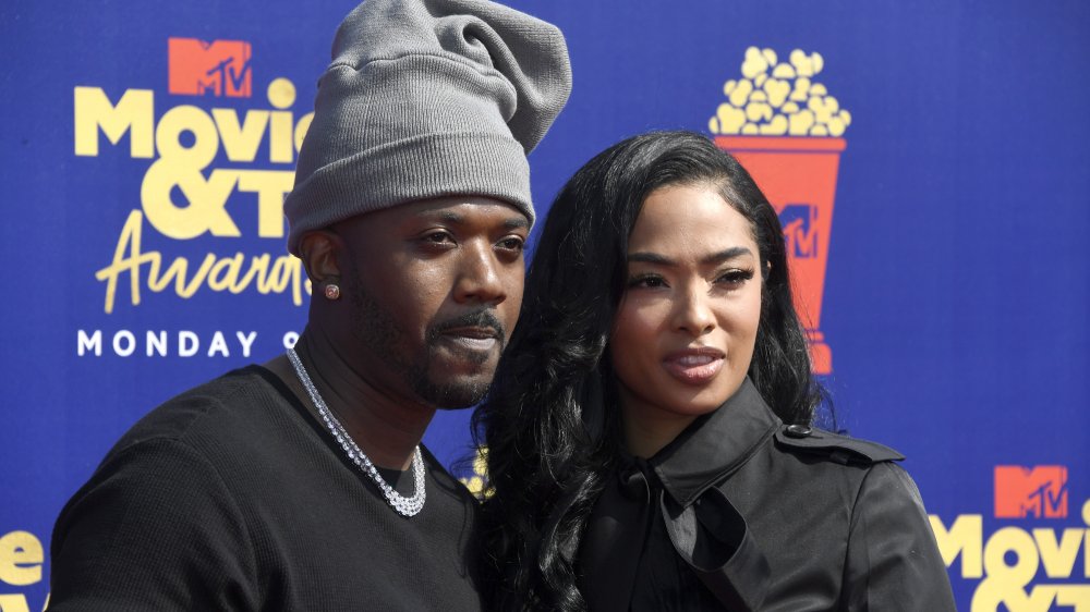 Ray J et Princess Love, vêtus de noir et posant bras dessus bras dessous sur le tapis rouge