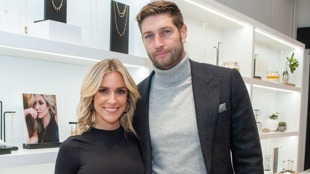 Kristin Cavallari et Jay Cutler, souriants tout en posant bras dessus bras dessous dans un magasin