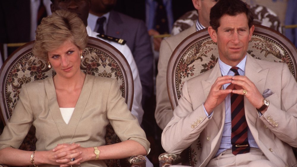 Princesse Diana et le prince Charles, assis à côté de l’autre dans des tenues de bronzage, les deux avec des expressions sérieuses