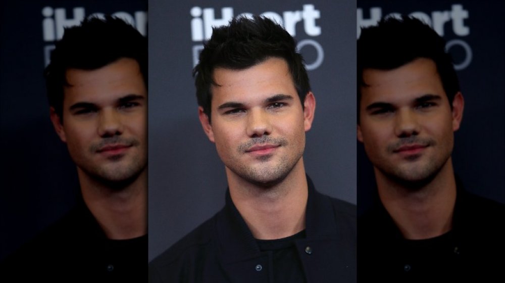 Taylor Lautner en tout noir, posant avec une expression neutre au festival de musique iHeartRadio 2016