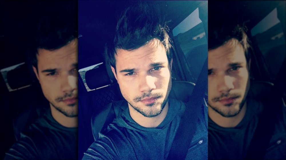 Taylor Lautner posant dans sa voiture pour un selfie