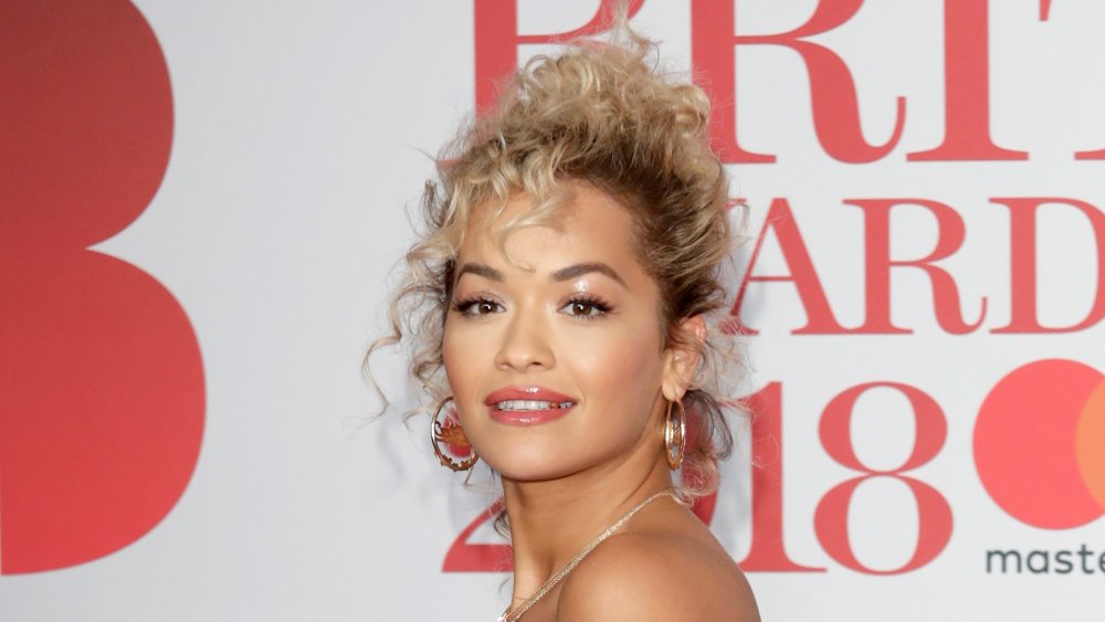 Rita Ora with hair done up and gold earrings