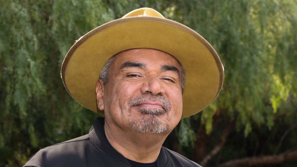 George Lopez debout à l'extérieur et souriant