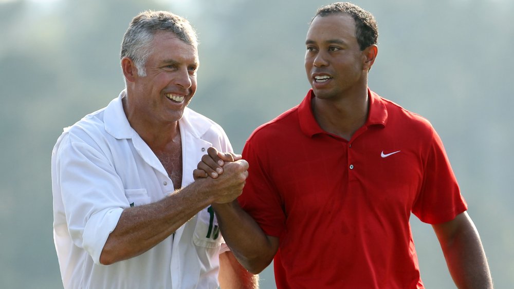 Steve Williams et Tiger Woods se serrant la main et souriant sur le terrain de golf