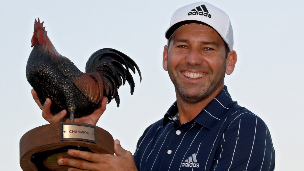 Sergia Garcia souriant et tenant un trophée de poulet