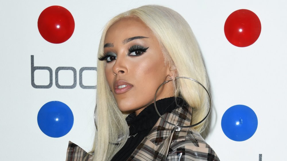 Doja Cat avec des cheveux blonds platine et de grandes créoles 