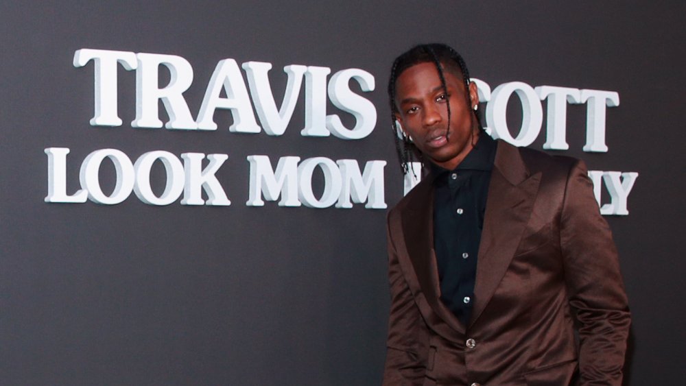 Travis Scott posant devant le titre de son album 