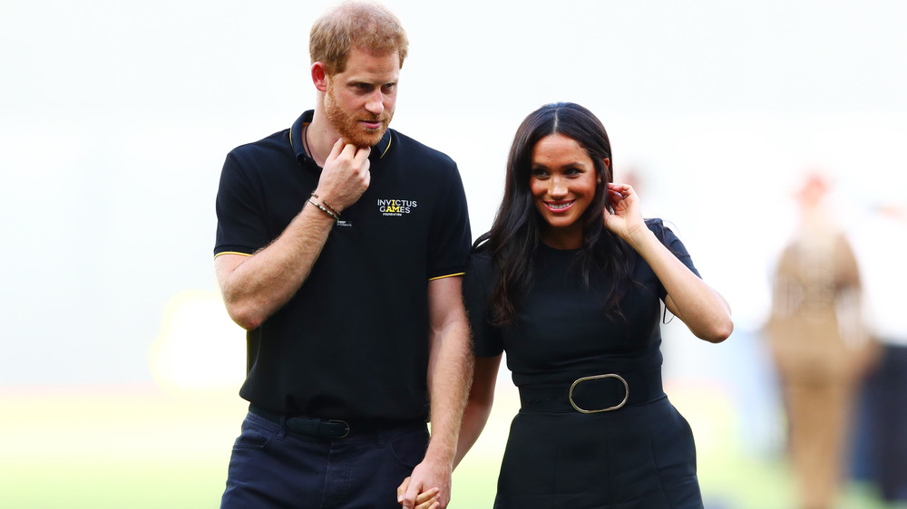 Prince Harry et Meghan Markle se tenant la main