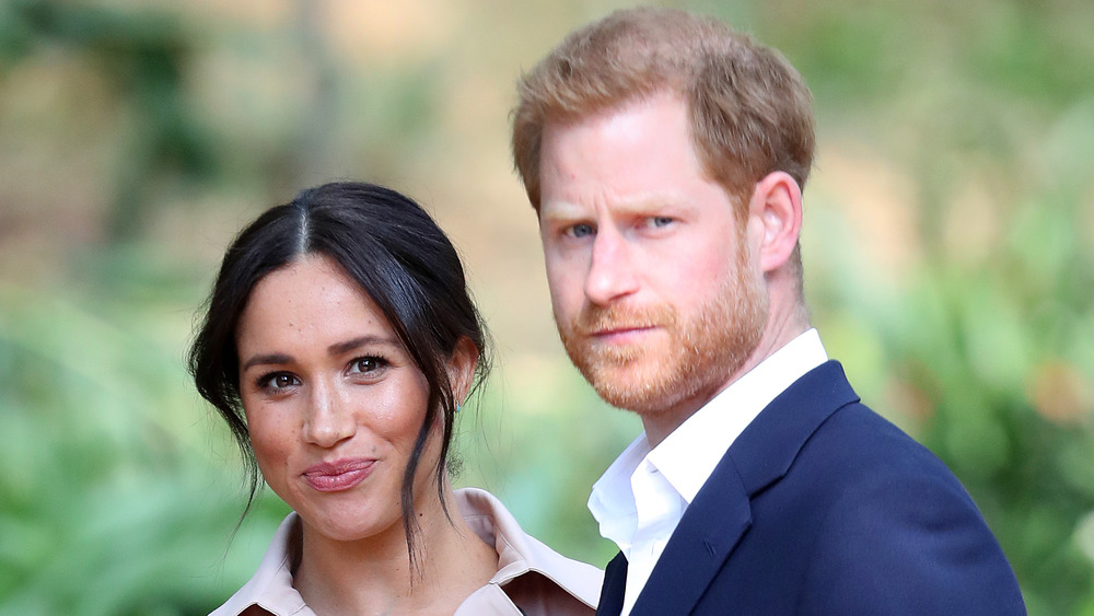 Meghan Markle et le prince Harry debout à l'extérieur