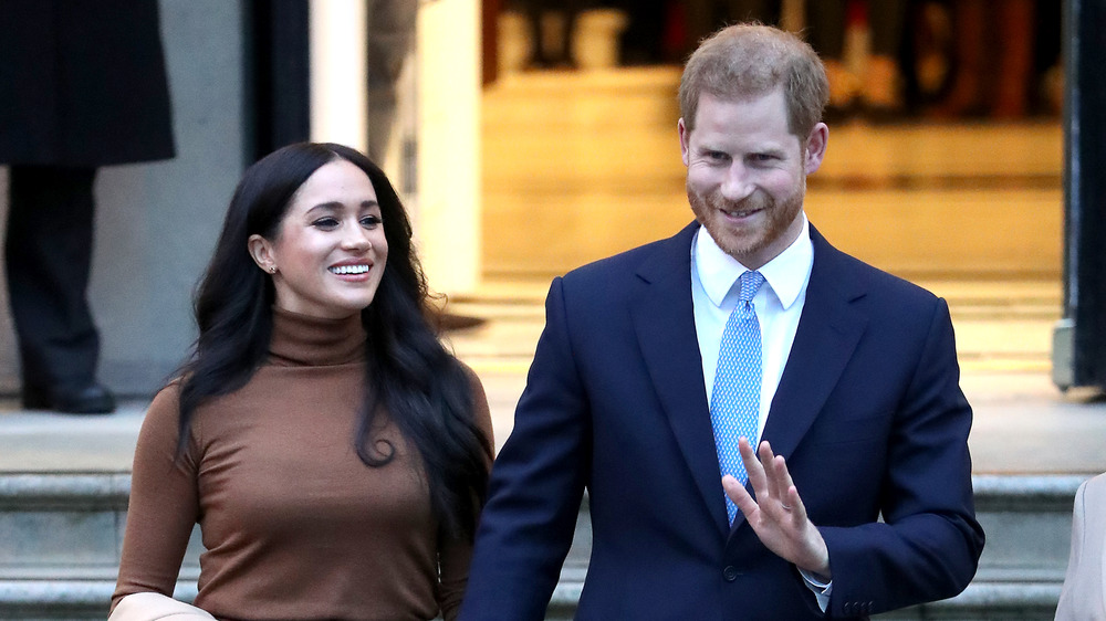 Meghan Markle et le prince Harry souriant et agitant