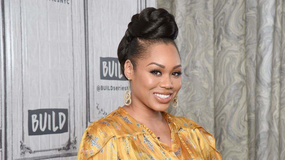 Monique Samuels souriant sur un tapis rouge