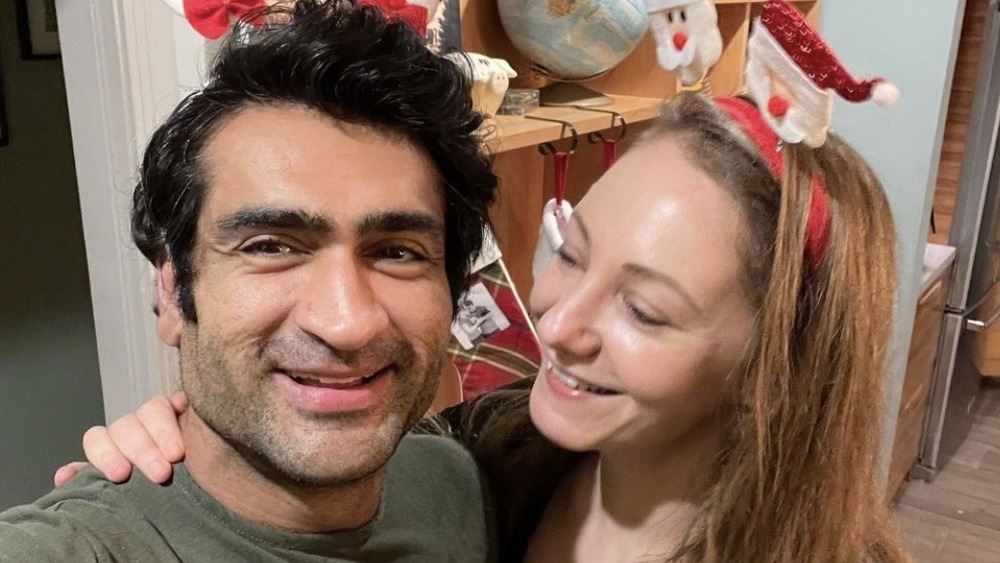 Kumail Nanjiani, selfie, souriant, en chapeau de Noël; Emily Gordon, souriante, au chapeau de Noël, regardant son mari 