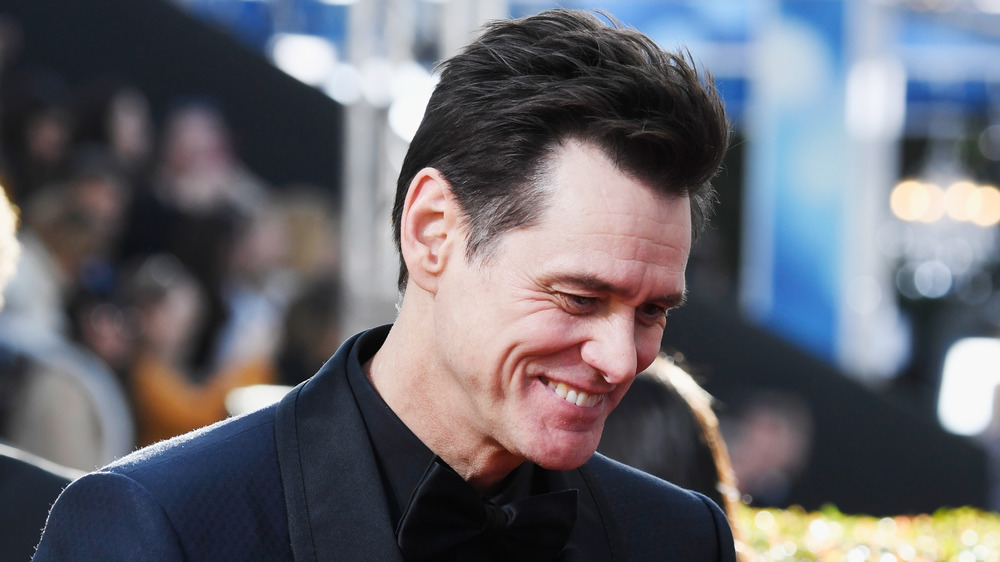 Jim Carrey souriant, regardant vers le bas 