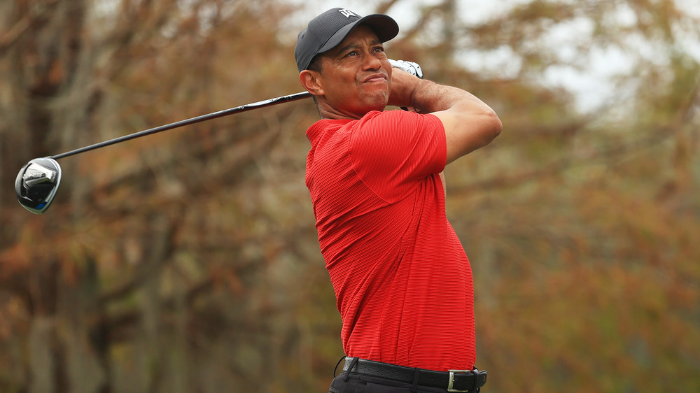 Tiger Woods balance un club de golf