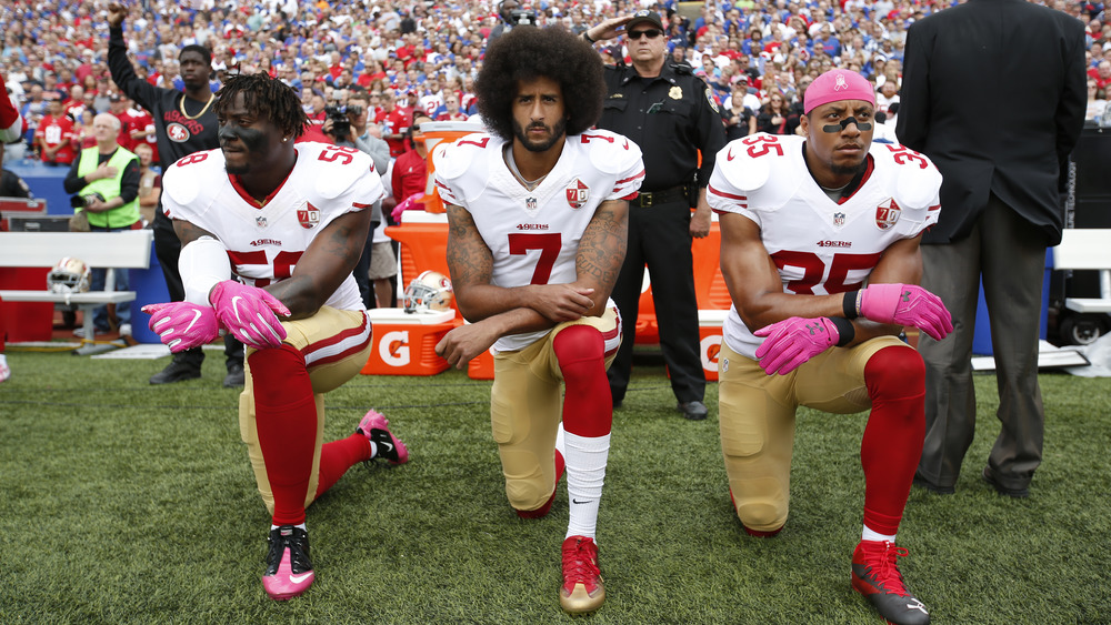 Eli Harold, Colin Kaepernick et Eric Reid agenouillés pour protester