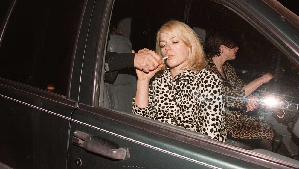 Un homme allume la cigarette d'Amanda de Cadenet 