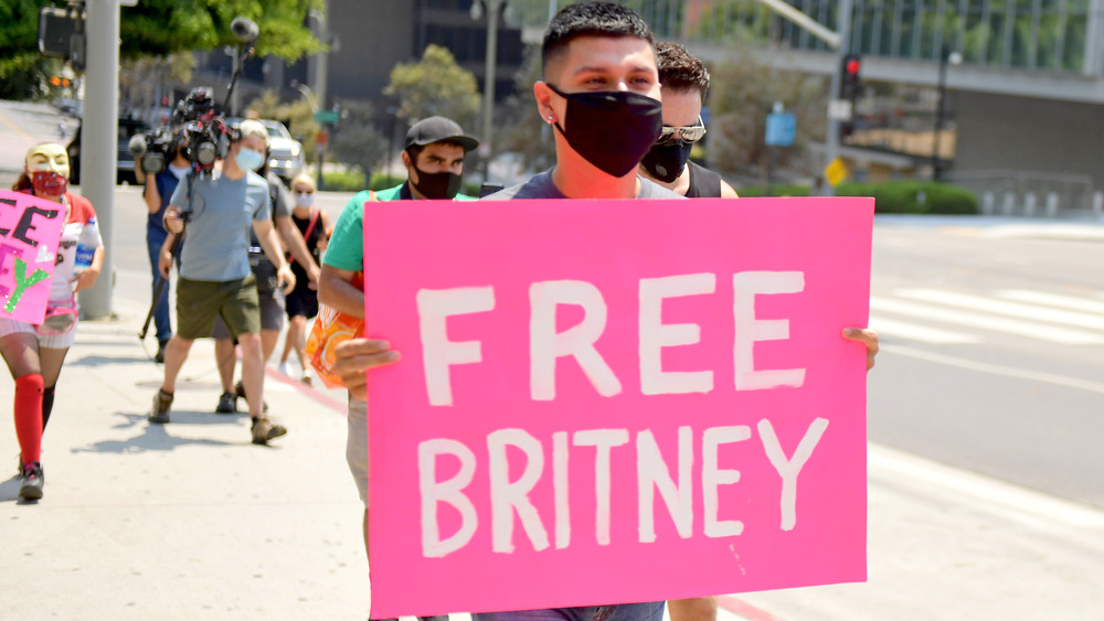 Un homme tenant une pancarte indiquant "Free Britney"