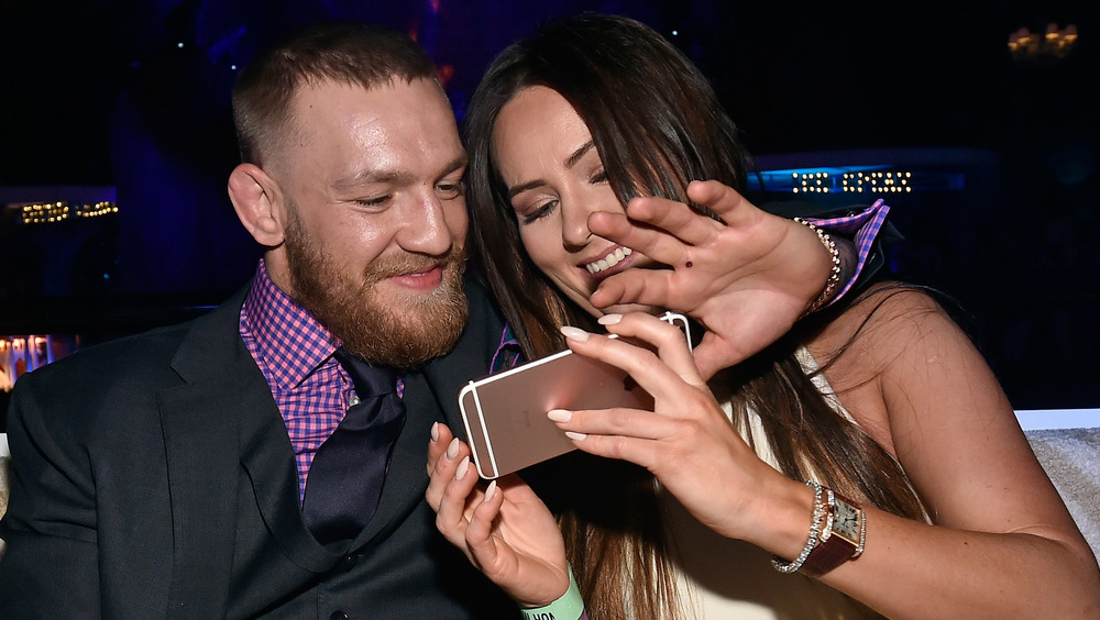 Connor McGregor et Dee Devlin regardent son téléphone