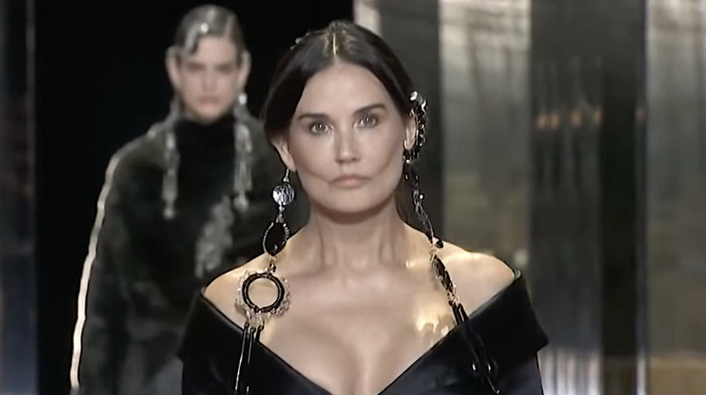 Demi Moore portant des boucles d'oreilles pendantes noires se promène dans un défilé Fendi