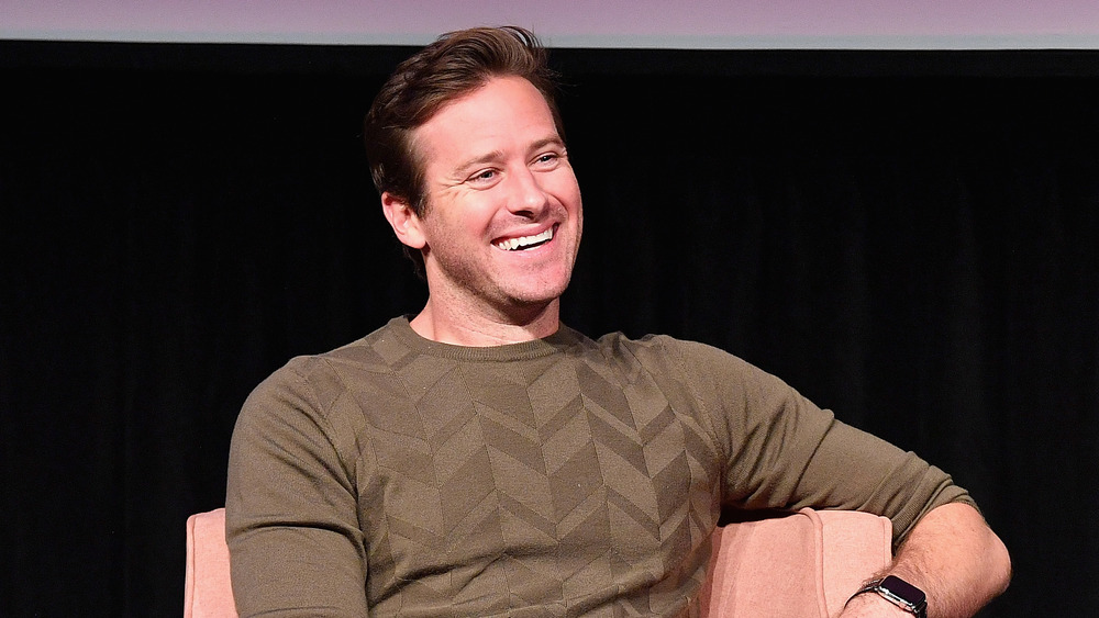 Armie Hammer riant et assis