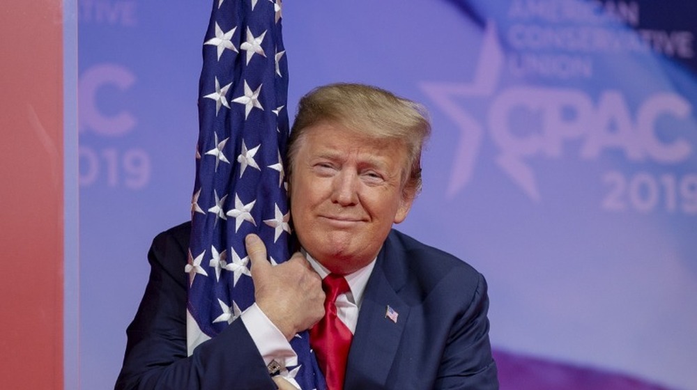 Le président américain Donald Trump embrasse le drapeau américain lors de CPAC 2019 le 02 mars 2019