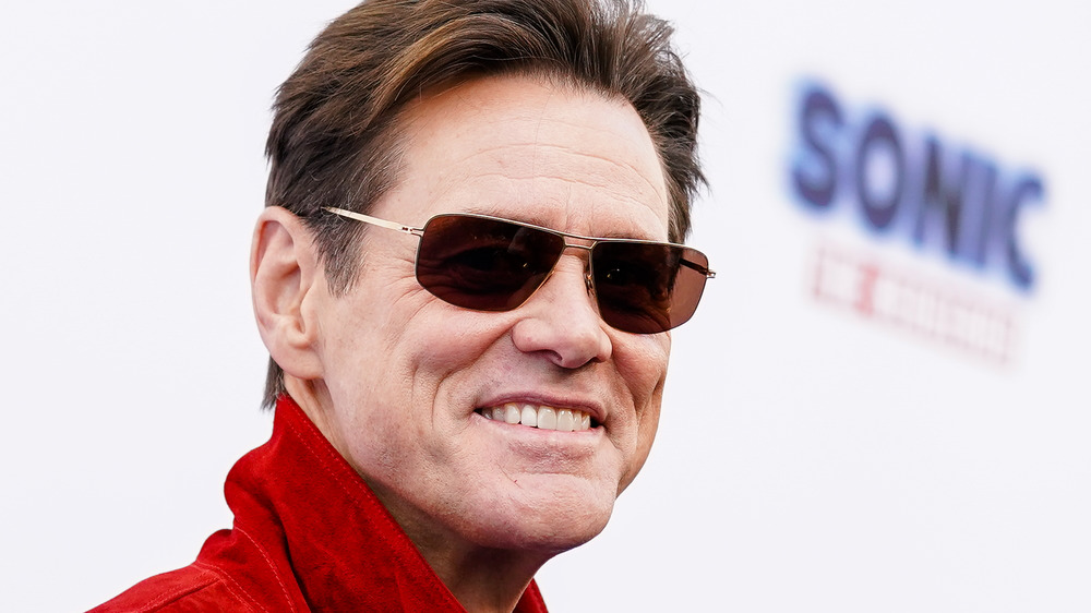 Jim Carrey souriant avec des lunettes de soleil sur