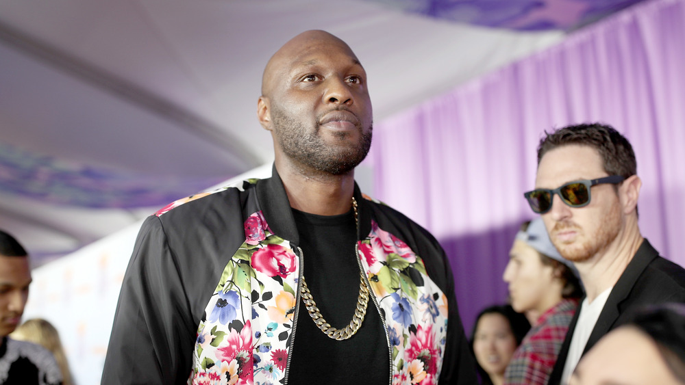 Lamar Odom perdu dans ses pensées, marchant sur le tapis rouge